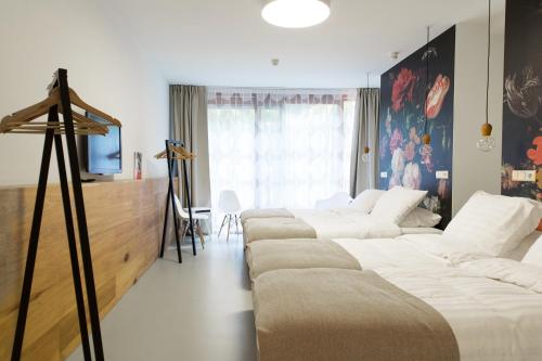 a room with four beds and a television in it at The Mansion in Amsterdam