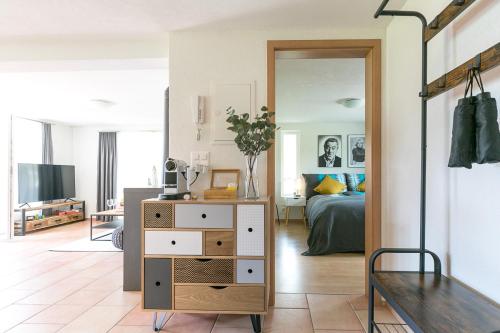a living room with a dresser and a bedroom at Spirit Apartments - XXL-Apt mit Balkon und Seesicht in Brienz