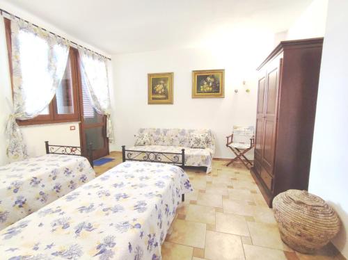 - un salon avec deux lits et un canapé dans l'établissement Appartamento Carmen, à Bosa