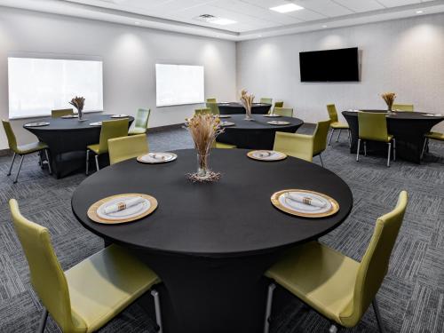 a conference room with tables and chairs and a screen at Holiday Inn Express & Suites - Ruskin by IHG in Ruskin