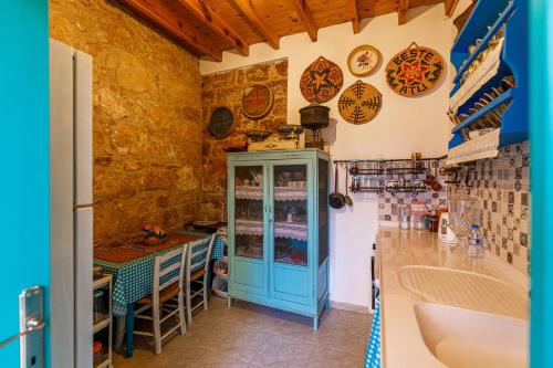 a kitchen with a blue cabinet and a table at Santa Napa Guest House in Famagusta