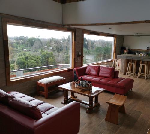 uma sala de estar com dois sofás e uma mesa em Altavista comodidad modernidad y seguridad em Ranco