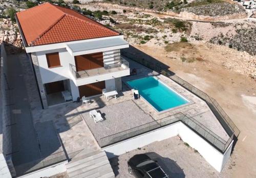 Cette chambre offre une vue sur une maison dotée d'une piscine. dans l'établissement Dubrovnik Heights, à Ivanica