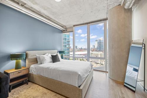 a bedroom with a bed and a large window at Placemakr Premier SoBro in Nashville