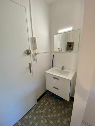 une salle de bain blanche avec un lavabo et un miroir dans l'établissement Studio 30 - Résidence Beauséjour - Fibre Wi Fi - Proche centre ville, à Troyes