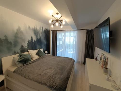 um quarto com uma cama e uma grande janela em Apartament rafinat cu grădină privată em Floresti