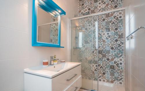 a bathroom with a shower and a sink and a mirror at Blue Waves Apartment with Maltese Balcony in Valletta