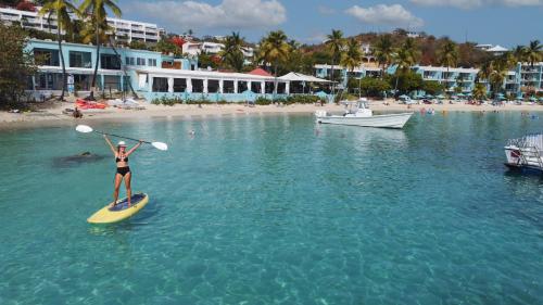 a woman on a paddle board in the water at Secret Harbour Beach Resort in St Thomas