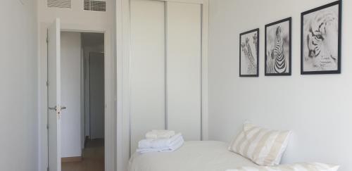 a white room with a white couch and a mirror at Sun & Relax in Denia Beach in Denia