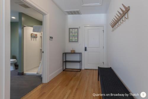 um quarto com um corredor com uma porta e pisos em madeira em West Broadway Quarters by Thatch em Boston