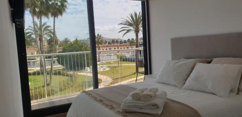 1 dormitorio con cama y ventana grande en Sun & Relax in Denia Beach, en Denia