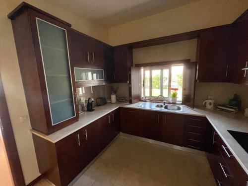 a kitchen with wooden cabinets and a sink and a window at Herdade do Gizo - Casa Reis in Cuba
