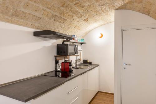 una cucina con piano di lavoro e forno a microonde di Just Here apartments - Lascia Fare a Dio a Bari