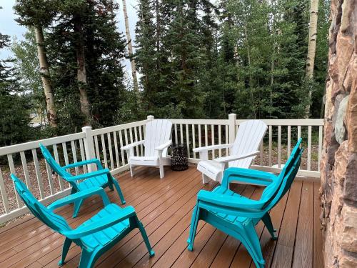 three chairs sitting on the deck of a house at Brian Head Cabin - 1 Mile from ALL SKI LIFTS! Cozy, Spacious & lots of fun in Brian Head