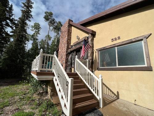 a house with a staircase and an american flag at Brian Head Cabin - 1 Mile from ALL SKI LIFTS! Cozy, Spacious & lots of fun in Brian Head