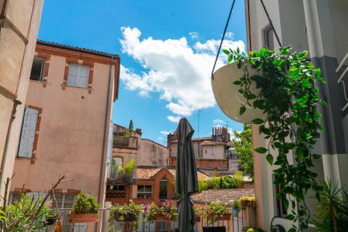 a view of a city from a street with an umbrella at Hôtel Croix Baragnon in Toulouse