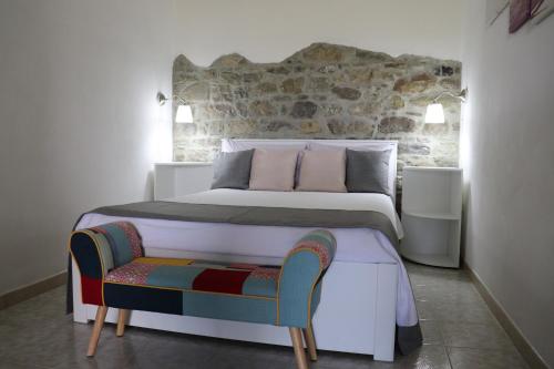 a bedroom with a large bed and a chair at Il Terrazzo Sul Sinni in Rotondella