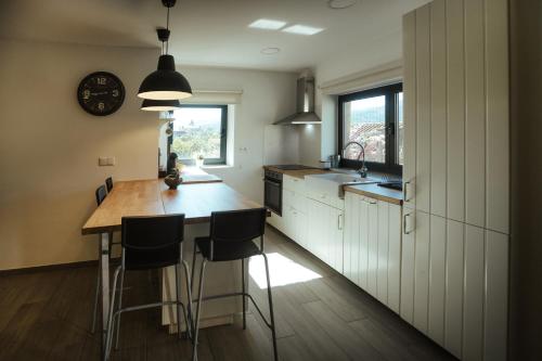 a kitchen with a table and chairs and a clock at Casa da Vila - Pool & Hot Tub with Mountain View in Gerês in Terras de Bouro