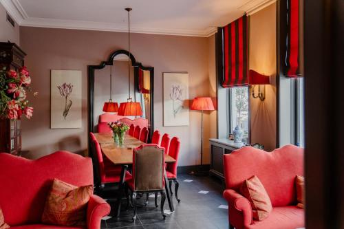 une salle à manger avec des chaises rouges et une table dans l'établissement Paleis Hotel, à La Haye