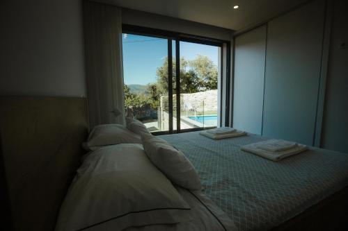 a bedroom with a bed with a view of a pool at Casa da Vila - Pool & Hot Tub with Mountain View in Gerês in Terras de Bouro