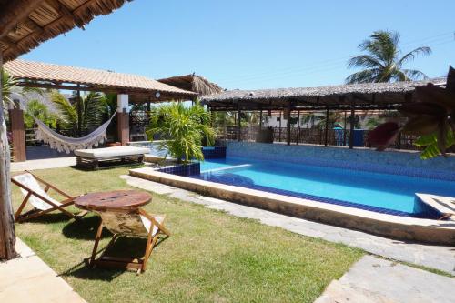 a resort with a pool and a table and chairs at Casa Nomade in Itarema