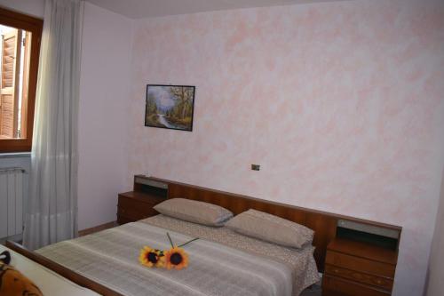 Casa Vacanze da Paola في Colli a Volturno: غرفة نوم مع سرير مع اثنين من زهور الشمس عليه