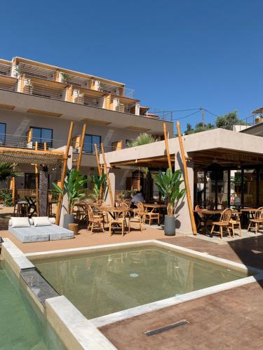 um hotel com piscina em frente a um edifício em Del Mare Suites em Glífa
