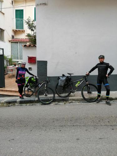 two people standing with their bikes on the side of a street at Holiday Home Zolfare in Comitini