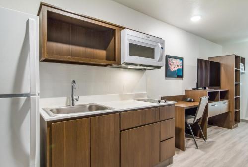 a kitchen with a sink and a microwave at WoodSpring Suites Greensboro - High Point North in Greensboro