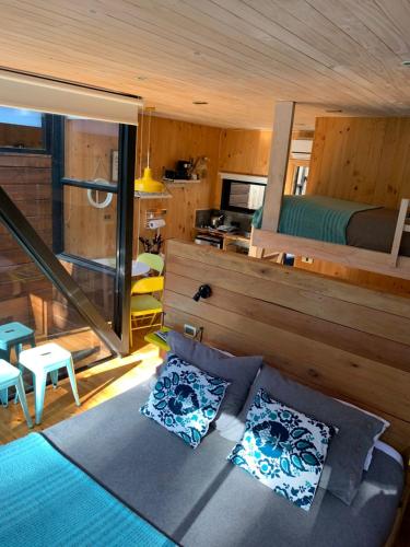 a living room with a bed and a bedroom at Lodge KARKÚ in Pichilemu