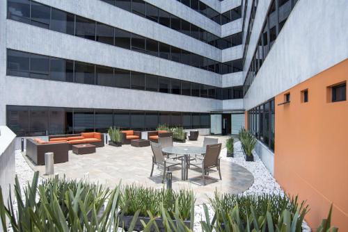 a patio with a table and chairs in front of a building at Hotel Brasilia in Mexico City