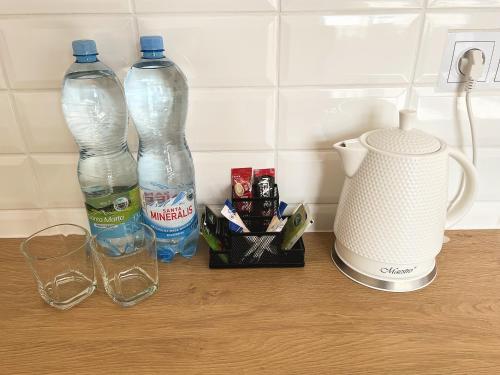 dos botellas de agua y una licuadora en un mostrador en White Apartments, en Katowice