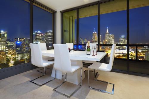 a white dining room with a view of the city at Platinum Luxury Stays at Freshwater Place in Melbourne