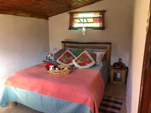 Un dormitorio con una cama con una cesta. en Chalé jeito de roça na Pedra Selada en Visconde De Maua