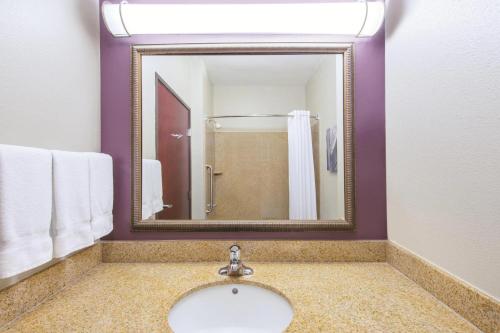 a bathroom with a sink and a mirror at La Quinta by Wyndham Oklahoma City -Yukon in Yukon