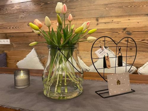 a vase with flowers in it on a table at Chalet Hoamat Leben in Leogang