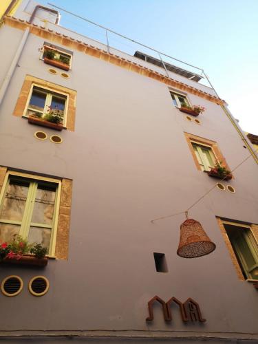 a white building with windows and a bell on it at Casa Pagiò in Bosa