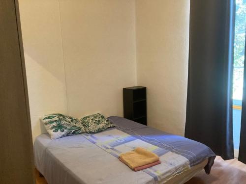 a small bed in a room with a window at feuillade ancien partagé in Nîmes