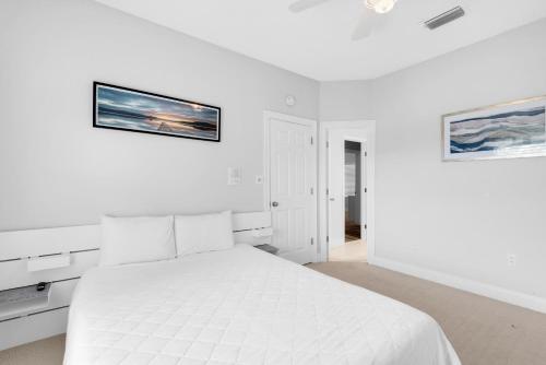 a white bedroom with a large white bed in it at Serenity by the Sea in Destin