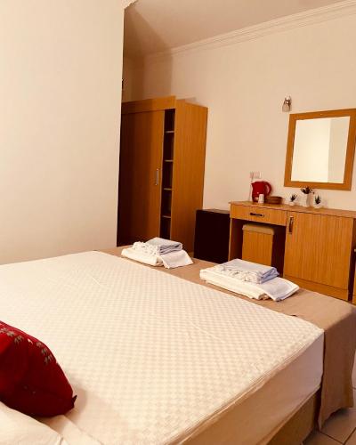 a bedroom with two beds and a dresser and a mirror at Kalia Beach Hotel Side in Side