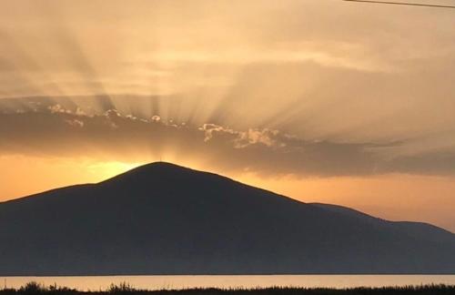 una silueta de una montaña con la puesta de sol detrás de ella en Apartments Vista Mar, en Orikum