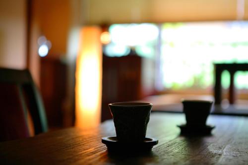 two cups sitting on top of a wooden table at Sakaeya in Yamanouchi