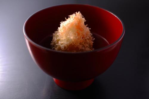 a red bowl with a piece of food in it at Sakaeya in Yamanouchi