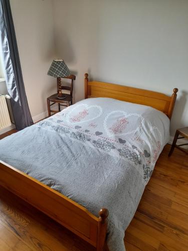 - un lit avec une couette blanche au-dessus dans l'établissement Apigîte68, proche route des vins, Vosges, Colmar et non loin d'Europa-Park!, à Ostheim