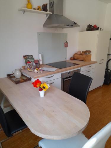 - une cuisine avec une table et des chaises fleuries dans l'établissement Apigîte68, proche route des vins, Vosges, Colmar et non loin d'Europa-Park!, à Ostheim