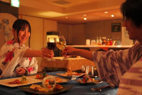 two people sitting at a table with a glass of wine at Sakaeya in Yamanouchi