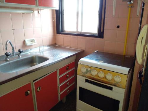 a small kitchen with a sink and a stove at depto a 50 m del casino y plaza principal "se aceptan mascotas" in Termas de Río Hondo