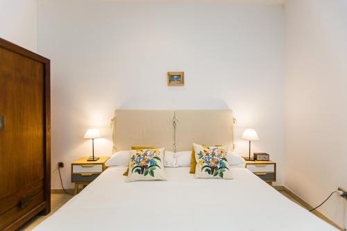 - une chambre avec un grand lit blanc et deux lampes dans l'établissement HERNANDO Colon 12, à Séville
