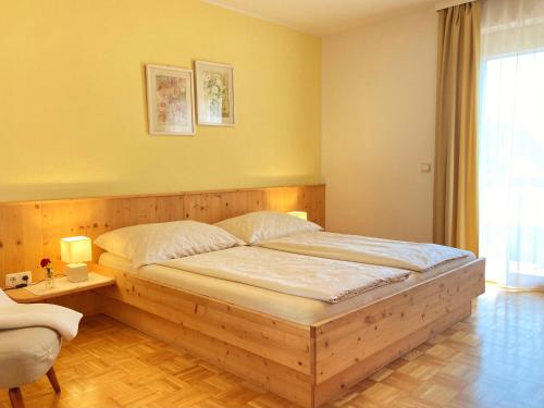 a bedroom with a wooden bed in a room at Ferienwohnung Sima in Velden am Wörthersee