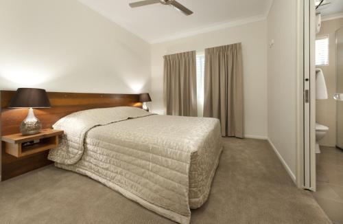 a hotel room with a bed and a bathroom at Apartments on Palmer in Rockhampton